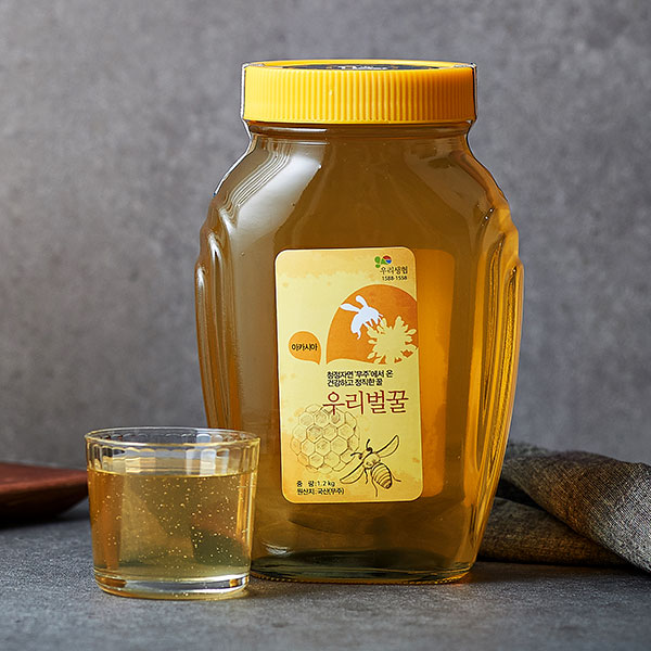 황금빛 아카시아꿀이 담긴 구천동벌꿀 병과 작은 유리잔